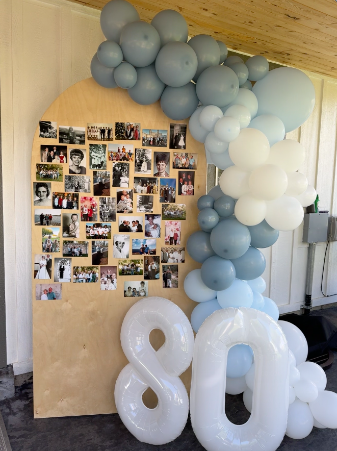 Decorative setup with balloons and a collage of photos on a wooden board.