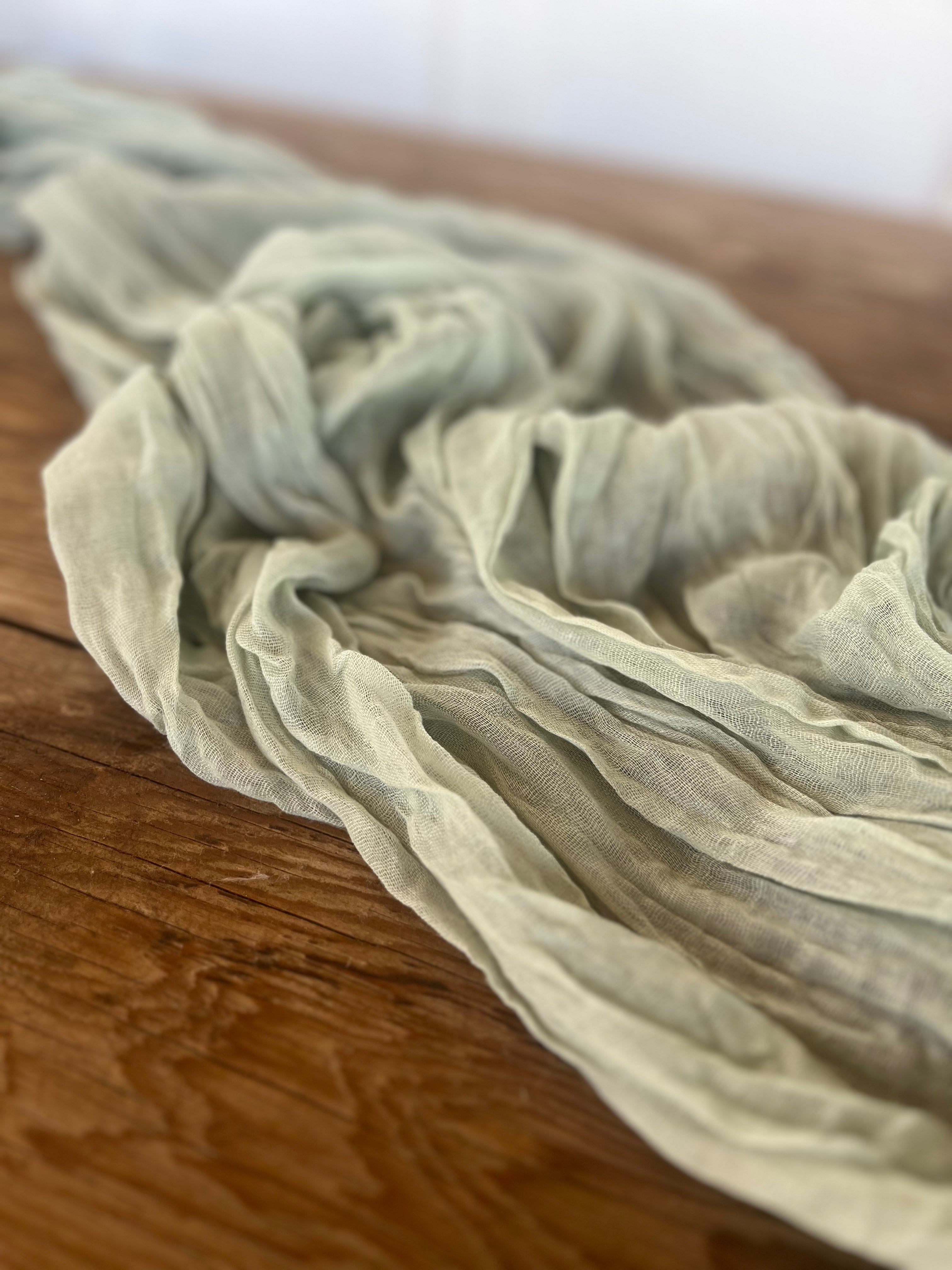Light green fabric draped over a wooden surface