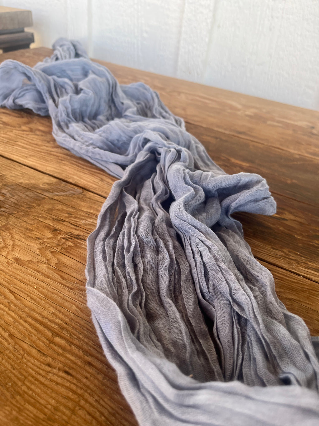 Gray blue fabric draped over a wooden surface with a blurred background