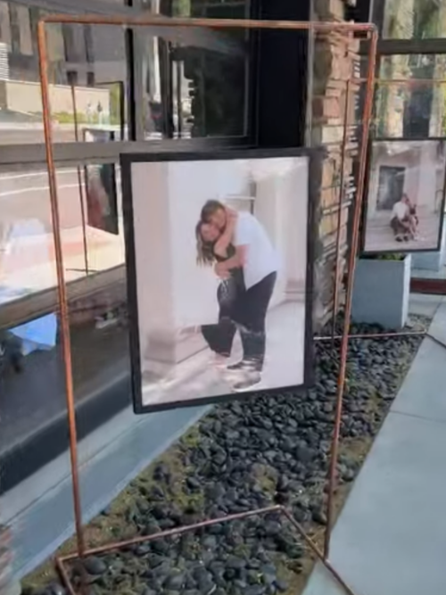 Framed picture of a couple embracing on a decorative metal stand.